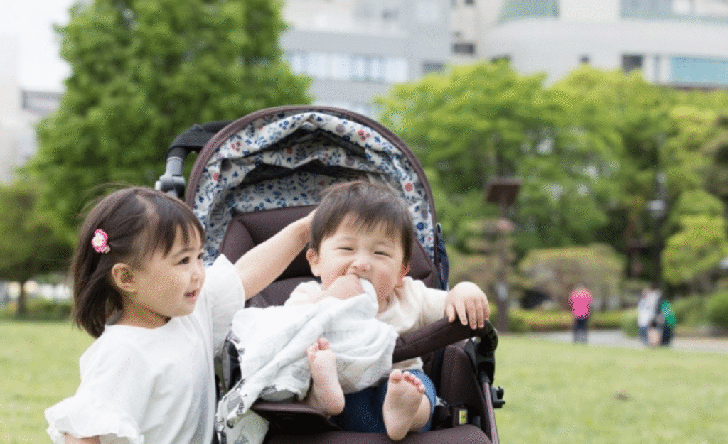 ベビーカーに乗る子供と姉