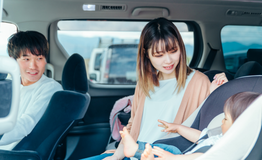 チャイルドシートに座る子供と家族