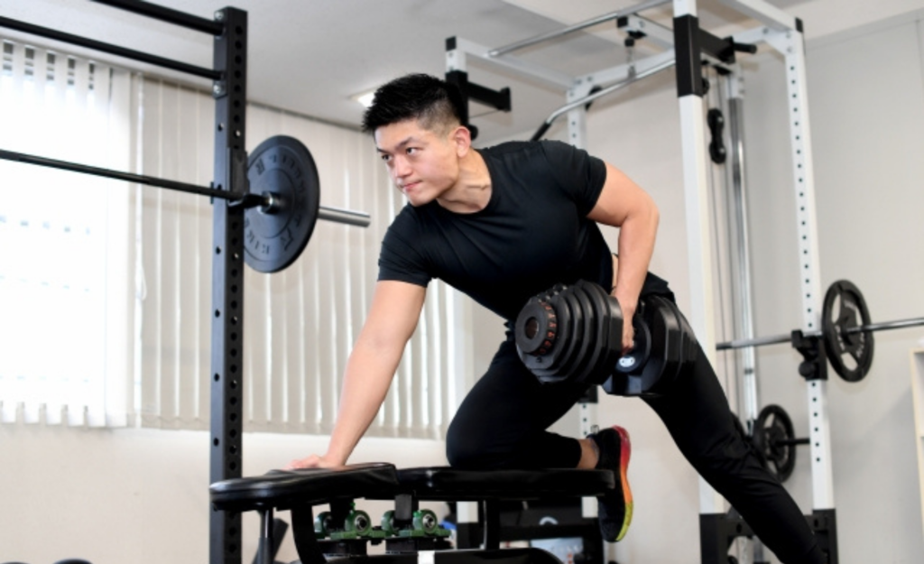 男性がダンベルをやっている